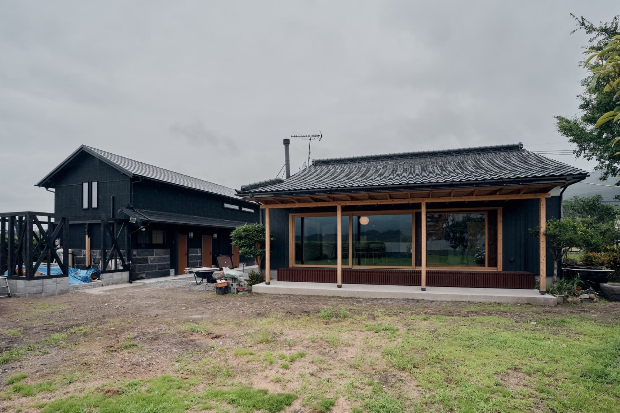 The two charred-black houses of Nagomi under a moody sky