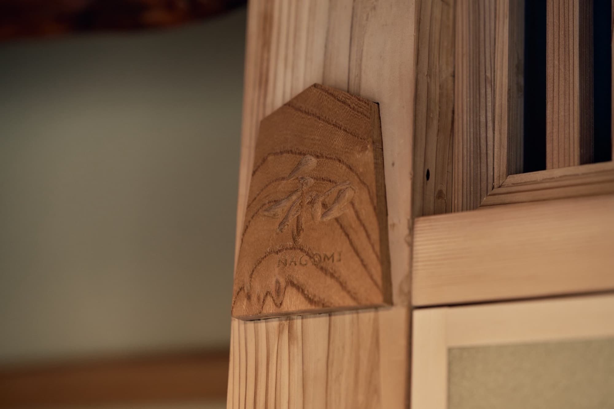 The carved 和 NAGOMI sign on a cedar post